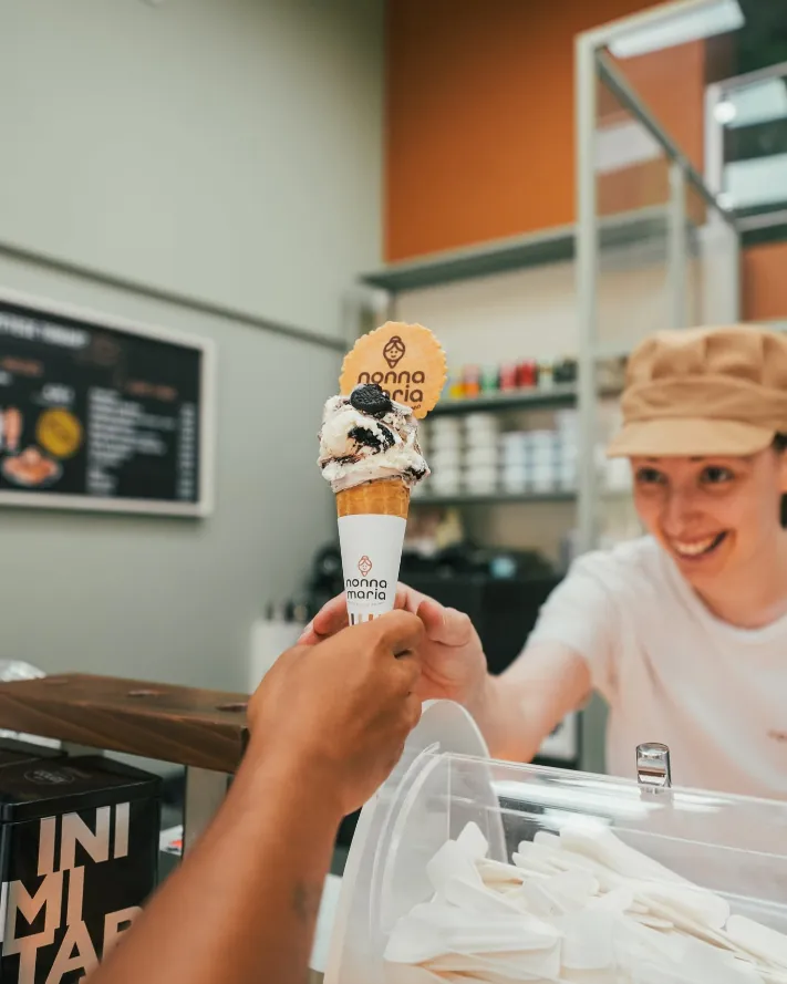 Dependienta entregando un cono con sonrisa